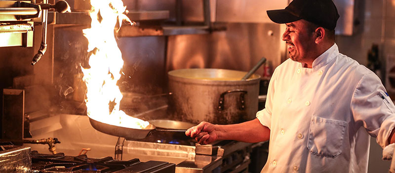 Chef in kitchen cooking on gas
