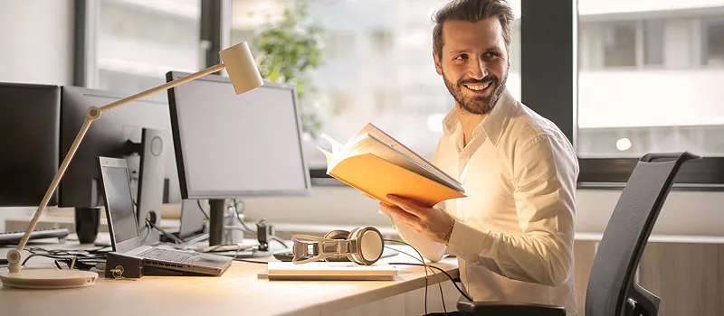 Businessman sitting at his desk at the office with a list of assets his business owns