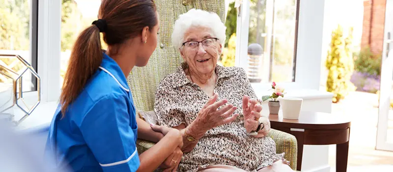 A care worker in a care home looking after the elderly