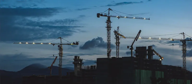 Big construction cranes on an urban building development site.