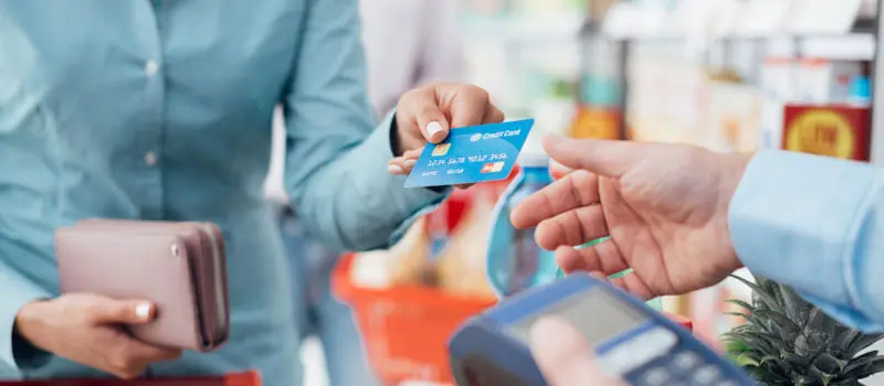 Convenience store owner taking payment from customer
