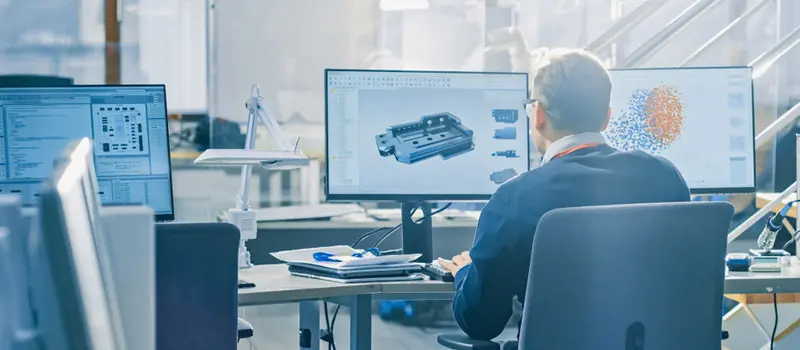 Engineering professional using CAD software on a computer to design technical components