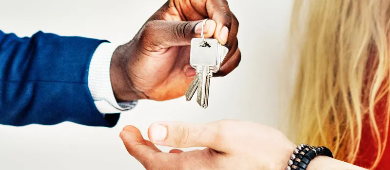 Landlord handing over keys to new tenants
