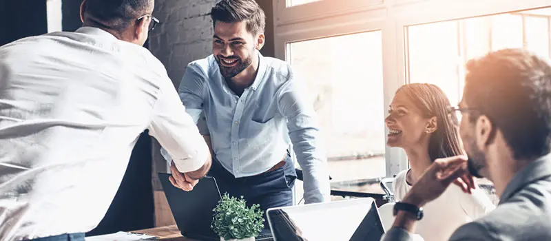 Management team shaking hands with business owner after making a deal