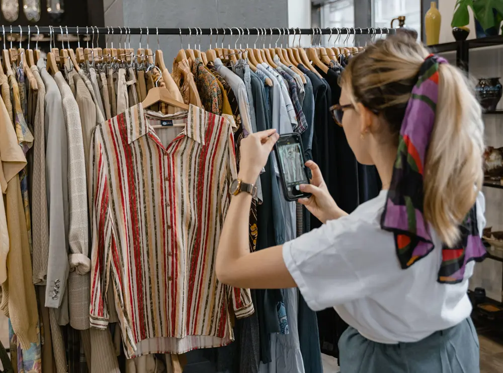 Woman photographing stylish clothing to list for sale on Vinted