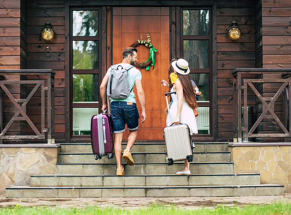 Guests arriving with luggage at Airbnb property.